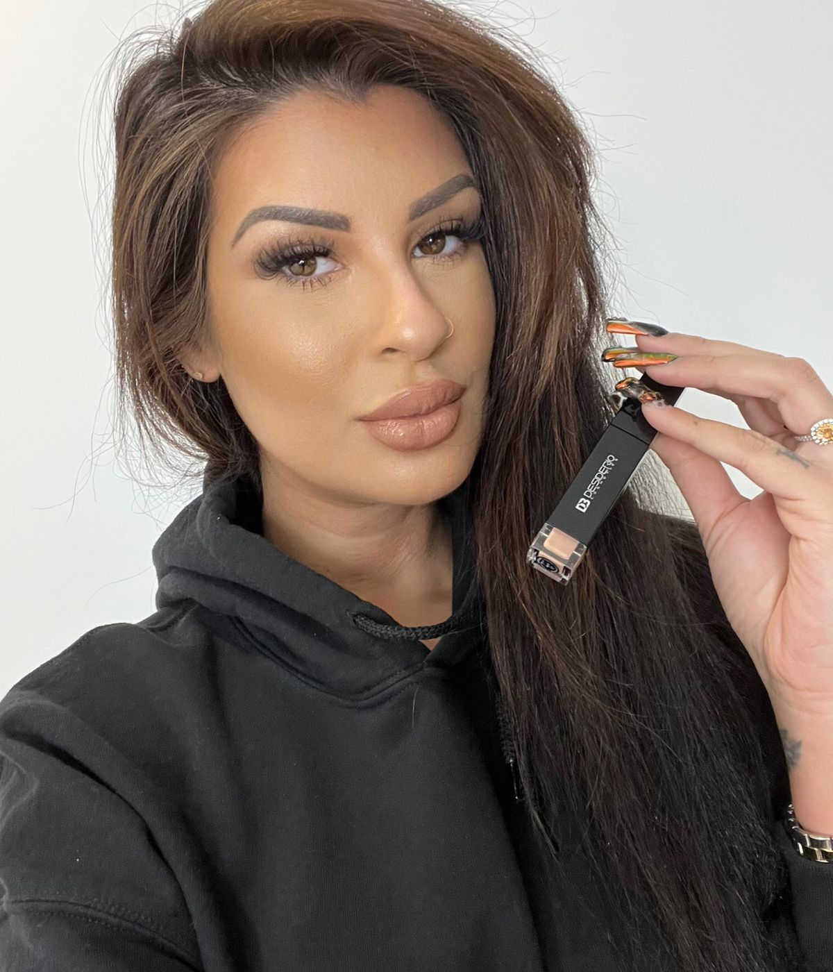A makeup artist holding a product from a brand partner.