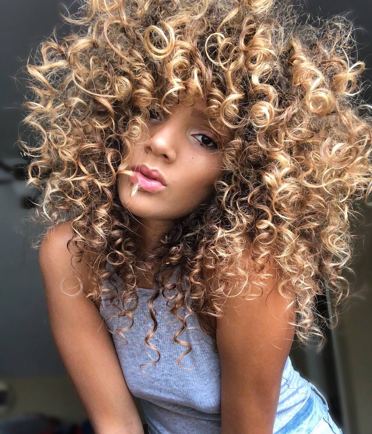 A close portrait of a finished curl cut and colour.